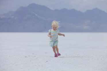 Kleines blondes Kleinkind, das unbeholfen über die Salinen von Utah läuft - AURF03213