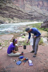Wanderer kochen ihr Abendessen auf einer Veranda oberhalb des Camps und des Colorado River in der Nähe der Deer Creek Falls im Grand Canyon außerhalb von Fredonia, Arizona, November 2011. - AURF03227