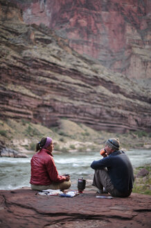 Wanderer kochen ihr Abendessen auf einer Veranda oberhalb des Camps und des Colorado River in der Nähe der Deer Creek Falls im Grand Canyon außerhalb von Fredonia, Arizona, November 2011. - AURF03228