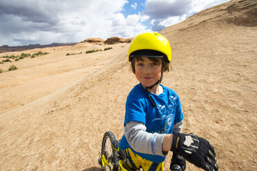 Kind auf seinem Mountainbike in der Wüste sitzend - AURF03253