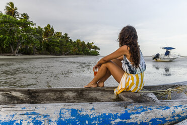 Junge Frau sitzt im Kanu am tropischen Strand, Insel Boipeba, Süd-Bahia, Brasilien - AURF03266
