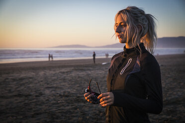 Young woman on beach at sunset, San Francisco, California, USA - AURF03294