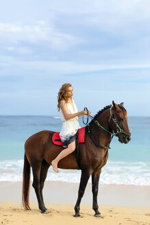 Young woman riding horse on beach - AURF03299
