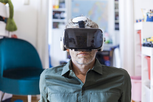 Porträt eines reifen Mannes zu Hause mit einer Virtual-Reality-Brille - TCF05818