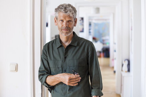 Portrait of mature man with grey hair and stubble at home - TCF05824