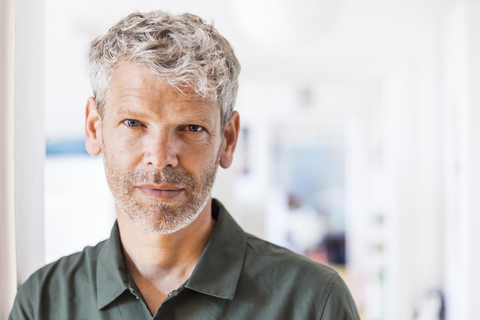 Porträt eines reifen Mannes mit grauem Haar und Bartstoppeln zu Hause, lizenzfreies Stockfoto