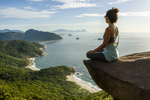 Woman sitting on edge of rock - AURF03306