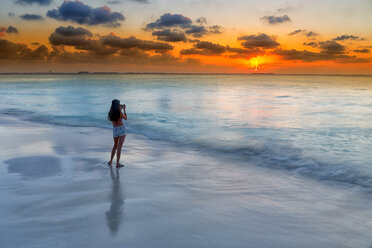 Frau fotografiert das Karibische Meer am Strand bei Sonnenuntergang, Isla Mujeres, Yucatan-Halbinsel, Mexiko - AURF03325