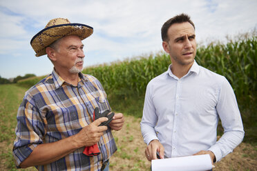 Landwirt und Geschäftsmann diskutieren auf dem Feld - ABIF00947