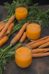 Three glasses of fresh carrot juice and carrots - JUNF01232