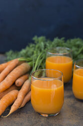 Drei Gläser mit frischem Karottensaft und Karotten - JUNF01233