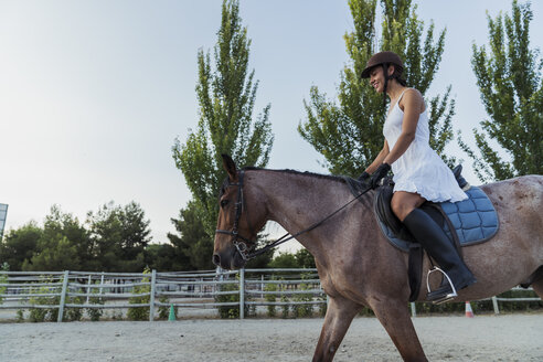 Smiling woman riding on horse - KKAF01571