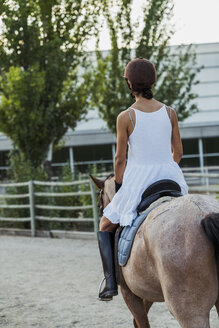 Rückenansicht einer Frau auf einem Pferd - KKAF01572