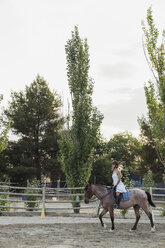 Frau reitet auf Pferd - KKAF01579