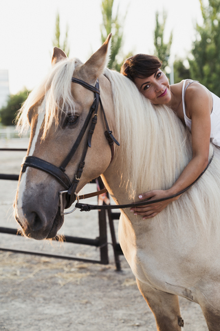 Porträt einer lächelnden Frau auf einem Reitpferd, lizenzfreies Stockfoto