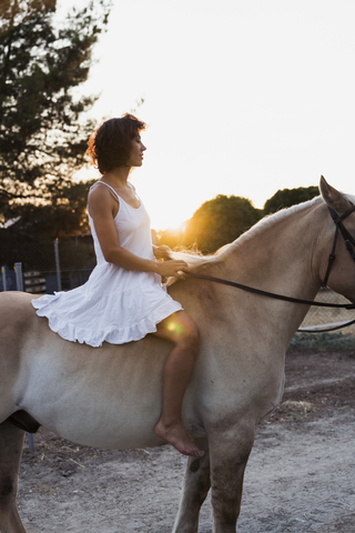 Barfüßige Frau reitet barfuß auf einem Pferd, lizenzfreies Stockfoto