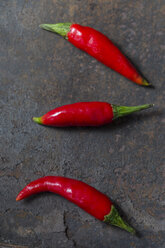 Drei Red Chilli Peppers auf rostigem Metall - JUNF01247