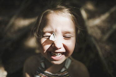 Porträt eines lachenden kleinen Mädchens mit Schmetterling im Gesicht - KMKF00463