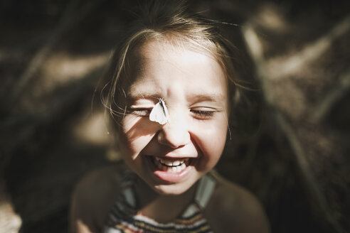 Portrait of laughing little girl with butterfly on her face - KMKF00463