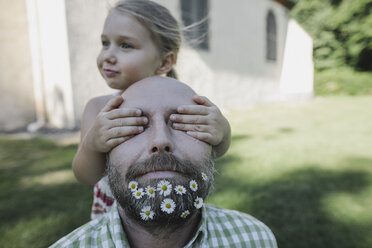 Die Hände eines kleinen Mädchens bedecken die Augen eines reifen Mannes mit Gänseblümchen in seinem Bart - KMKF00468