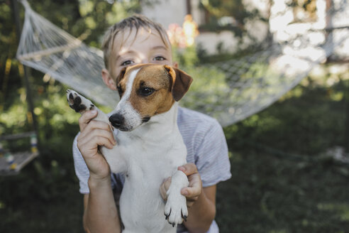 Junge mit Jack Russel Terrier im Garten - KMKF00484