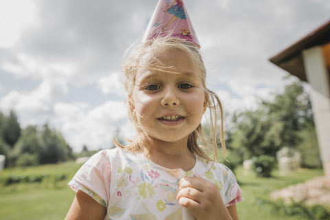 Porträt eines lächelnden kleinen Mädchens mit Papiertüte, lizenzfreies Stockfoto