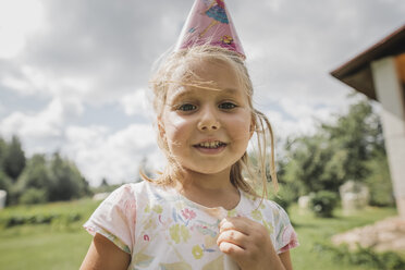 Porträt eines lächelnden kleinen Mädchens mit Papiertüte - KMKF00520