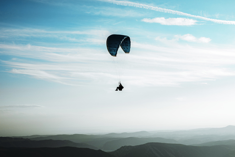 Gleitschirmfliegen, Gleitschirm, blauer Himmel mit Wolken, Berge, lizenzfreies Stockfoto