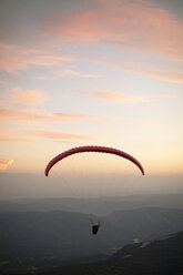 Gleitschirmfliegen mit Bergen im Hintergrund bei Sonnenuntergang - ACPF00318