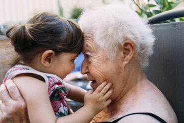 Grandmother face to face with her granddaughter on terrace - GEMF02374