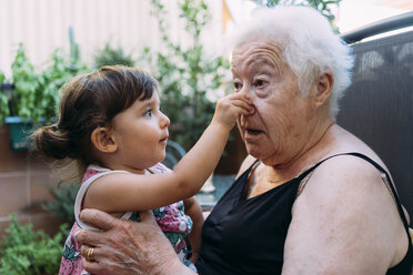 Großmutter und Enkelin spielen zusammen auf der Terrasse - GEMF02379