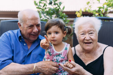 Großeltern und Enkelin verbringen Zeit miteinander auf der Terrasse - GEMF02380