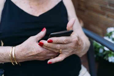 Hände einer älteren Frau, die ein Smartphone benutzt - GEMF02386