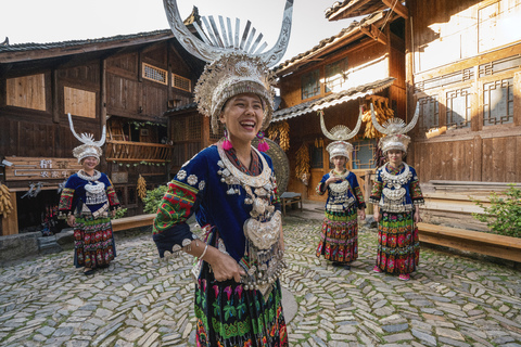 China, Guizhou, glückliche Miao-Frauen in traditionellen Kleidern und Kopfbedeckungen auf dem Dorfplatz, lizenzfreies Stockfoto