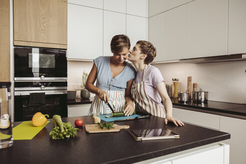 Glückliches lesbisches Paar in der Küche beim gemeinsamen Kochen - MFF04423