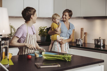 Glückliches lesbisches Paar und ihr Kind in der Küche - MFF04424
