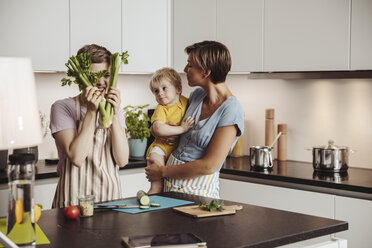 Verspieltes lesbisches Paar und ihr Kind in der Küche - MFF04425