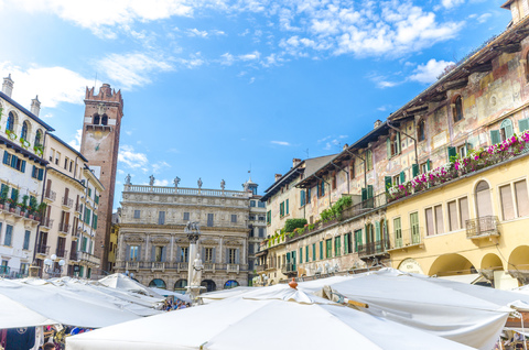 Italien, Verona, Blick auf die Piazza delle Erbe mit Ständen und Torre del Gardello im Hintergrund, lizenzfreies Stockfoto