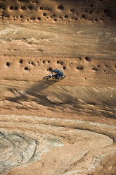 Mann beim Mountainbiking an einer vertikalen Wand in Moab, Utah. - AURF03336