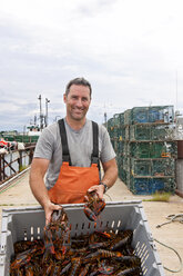 Lobsterman shows off catch on wharf - AURF03348