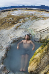 Ein Mann entspannt sich im Winter in den Travertine Hot Springs in den östlichen Sierras, Kalifornien. - AURF03359