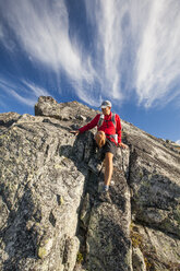A backpacker downclimbs a rocky step near Saxifrage Mountain, Pemberton, British Columbia, Canada. - AURF03620