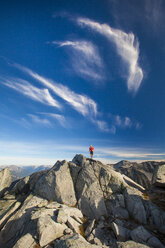 Ein Rucksacktourist steht auf einem felsigen Gipfel in der Nähe von Whistler, British Columbia, Kanada. - AURF03622