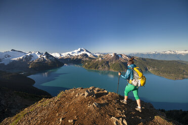 Ein Rucksacktourist erreicht den Gipfel des Panorama Ridge im Garibaldi Provincial Park, British Columbia, Kanada. - AURF03624