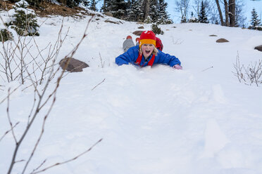 Ein Mädchen rutscht einen Schneehang im San Juan National Forest in Durango, Colorado, hinunter. - AURF03660