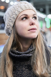 Porträt einer nachdenklichen blonden jungen Frau mit Wollmütze im Winter - IGGF00555