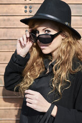 Mid adult woman wearing black hat and sunglasses - IGGF00559