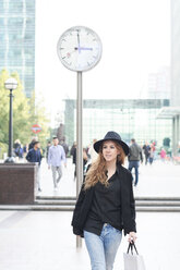 Mid adult woman wearing a hat going shopping in the city - IGGF00561