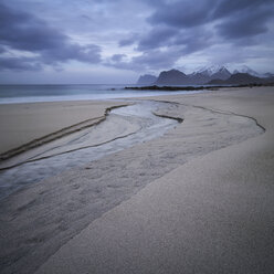 Ein kleiner Fluss fließt durch den Sand am Strand von Storsandnes, Flakstad├©y, Lofoten, Norwegen - AURF03726