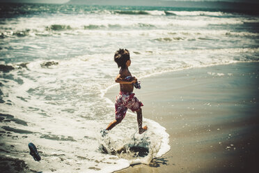 A young boy running on a beach. - AURF03793